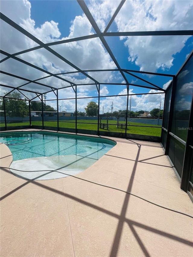 view of swimming pool with a lawn, a lanai, and a patio