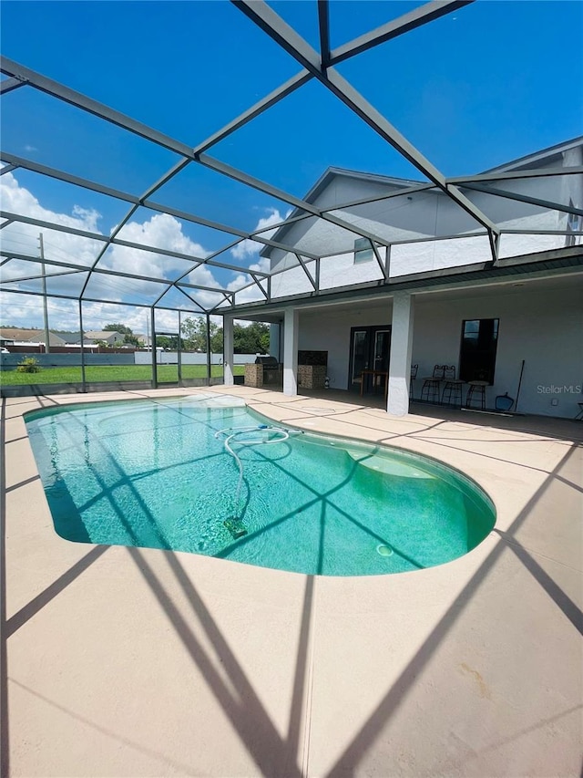 view of pool featuring glass enclosure and a patio area