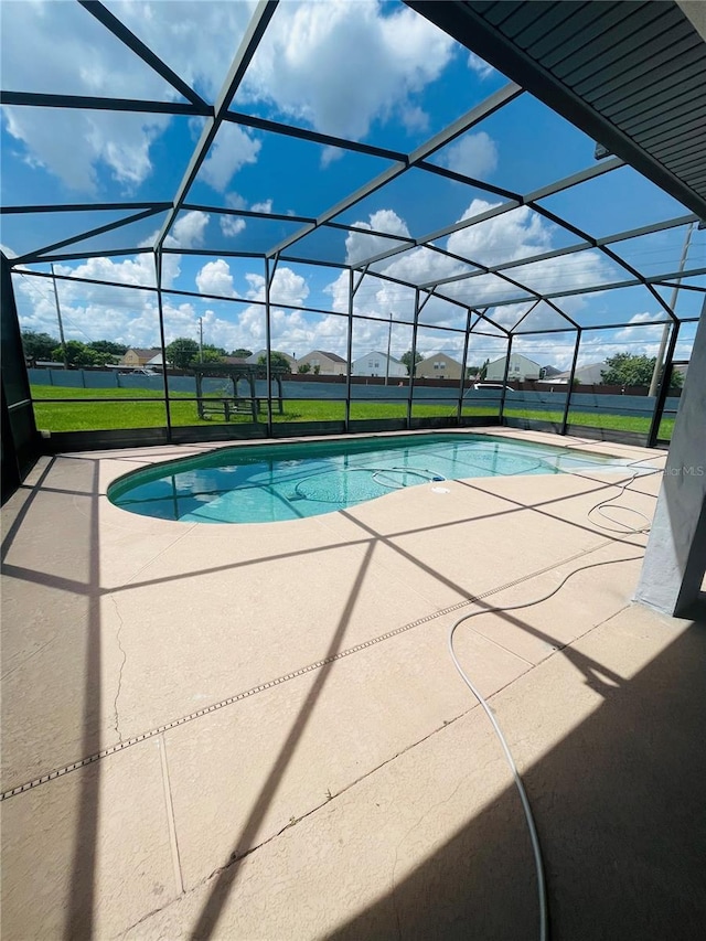 view of pool with a yard, a lanai, and a patio