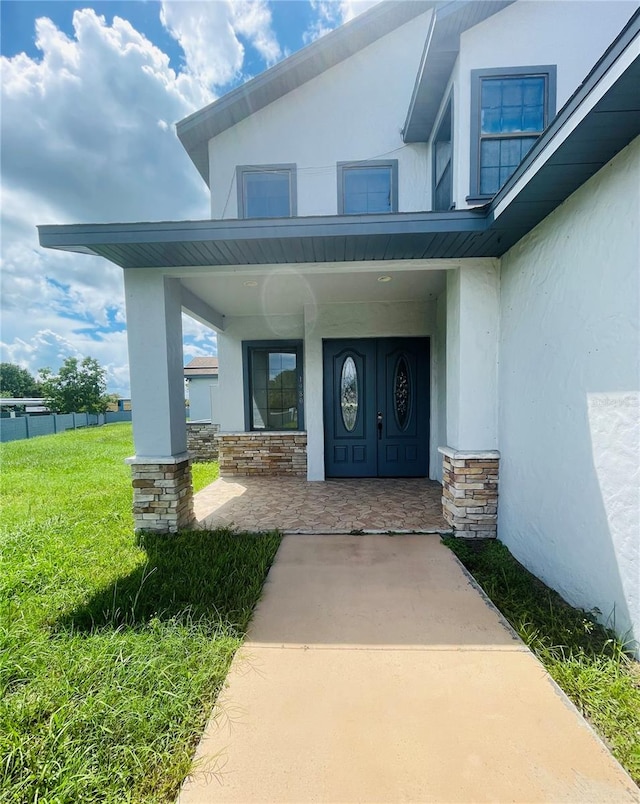 property entrance featuring a porch and a lawn