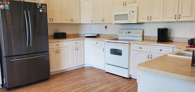 kitchen featuring light hardwood / wood-style flooring, white cabinets, and white appliances