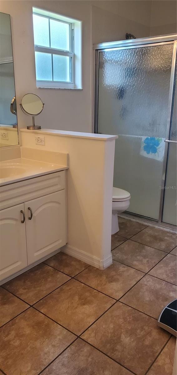 full bathroom featuring toilet, a stall shower, tile patterned floors, and vanity