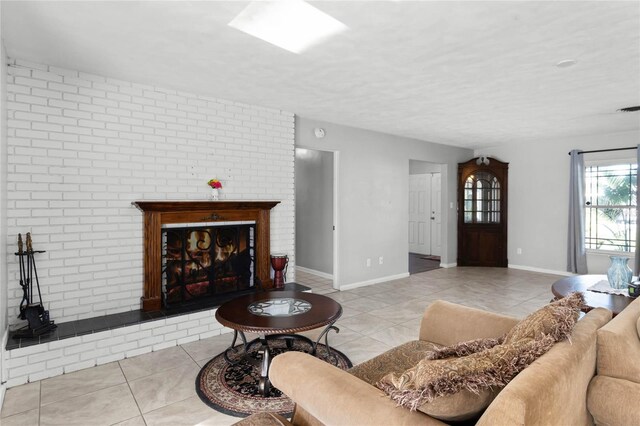 living room with light tile patterned flooring, brick wall, and a brick fireplace