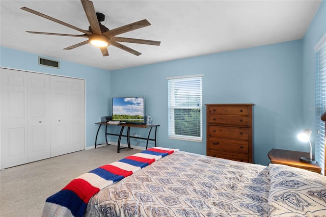 carpeted bedroom with ceiling fan and a closet