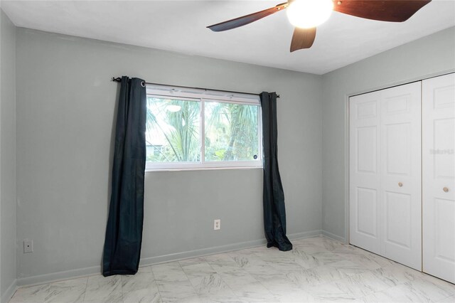 unfurnished bedroom with ceiling fan and a closet