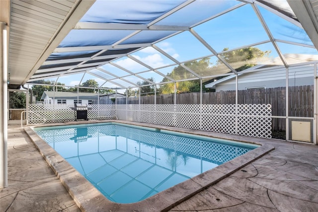 view of pool featuring glass enclosure and a patio area