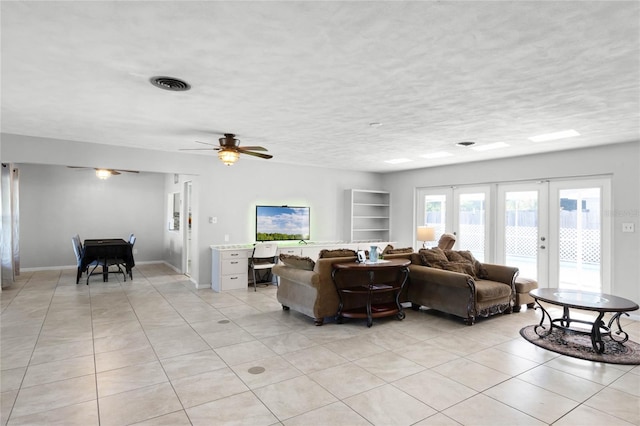 living room featuring ceiling fan, light tile patterned flooring, a textured ceiling, and french doors