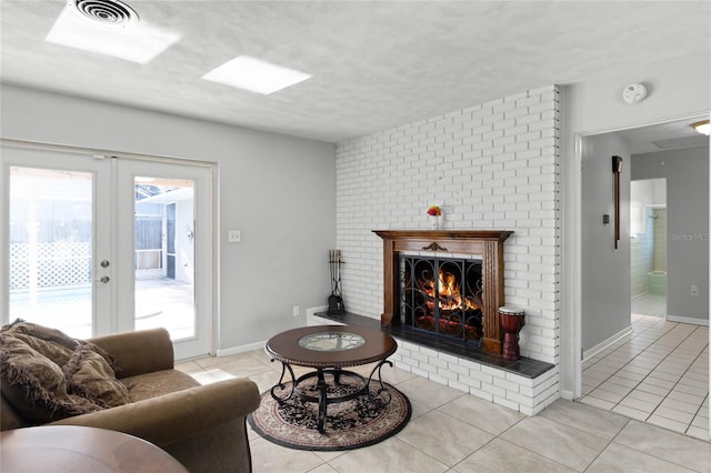 living room with a fireplace, french doors, and light tile patterned floors