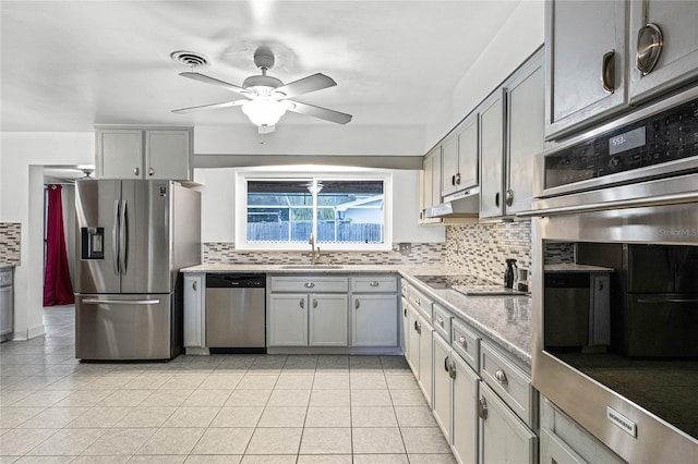 kitchen featuring gray cabinetry, stainless steel appliances, and tasteful backsplash