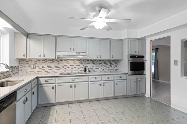 kitchen with backsplash, ceiling fan, sink, and appliances with stainless steel finishes