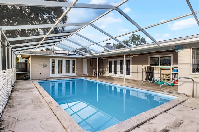 view of swimming pool with french doors, a patio, ceiling fan, and a lanai