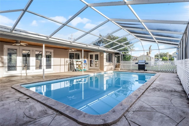 view of pool with french doors, area for grilling, a lanai, ceiling fan, and a patio area