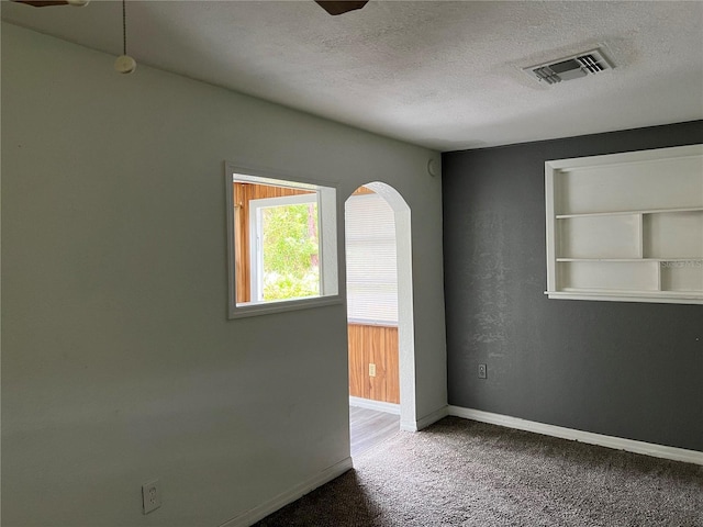 6790 Bass Hwy, Saint Cloud, FL 34771 - carpeted empty room with a textured ceiling, arched walkways, baseboards, and built in features
