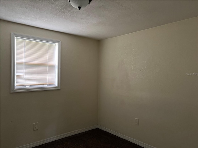 unfurnished room with a textured ceiling