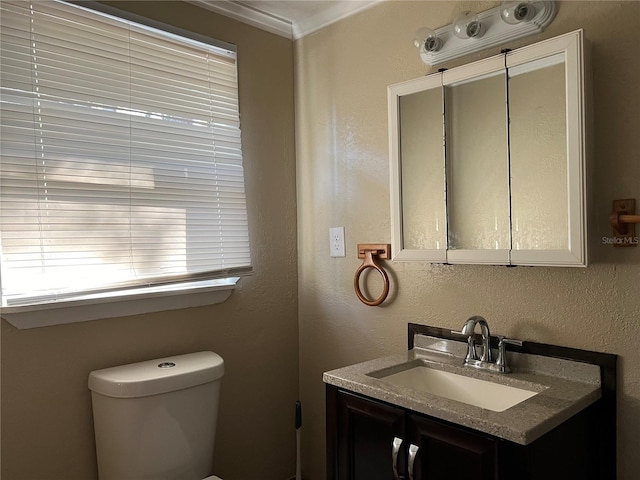 bathroom with vanity, toilet, and crown molding