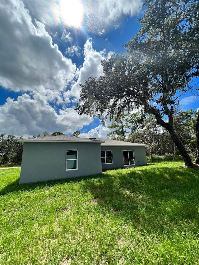 rear view of house featuring a yard