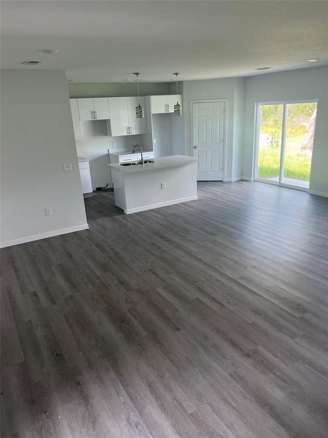 unfurnished living room featuring sink and dark hardwood / wood-style floors