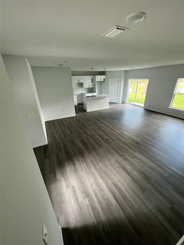 unfurnished living room featuring dark hardwood / wood-style flooring and sink