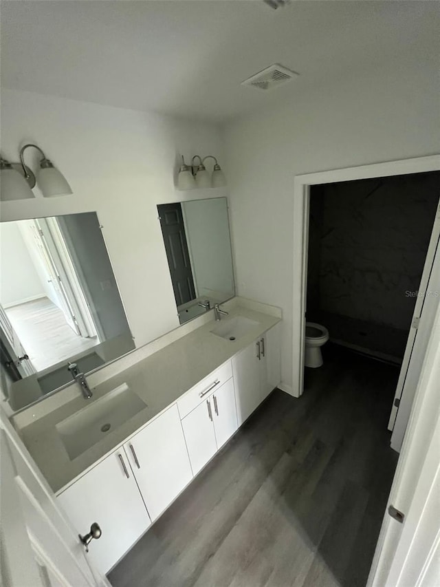 bathroom featuring vanity, toilet, and hardwood / wood-style floors