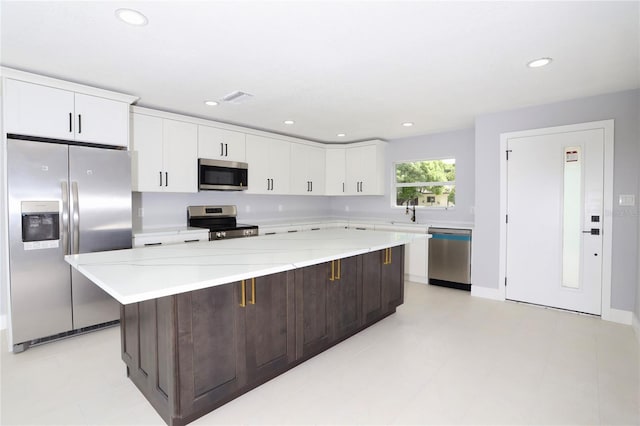 kitchen featuring a center island, a breakfast bar area, sink, white cabinets, and stainless steel appliances