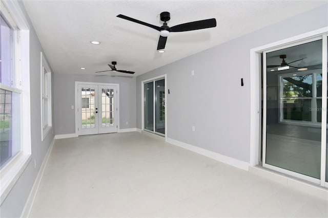 unfurnished room with a textured ceiling, ceiling fan, and french doors