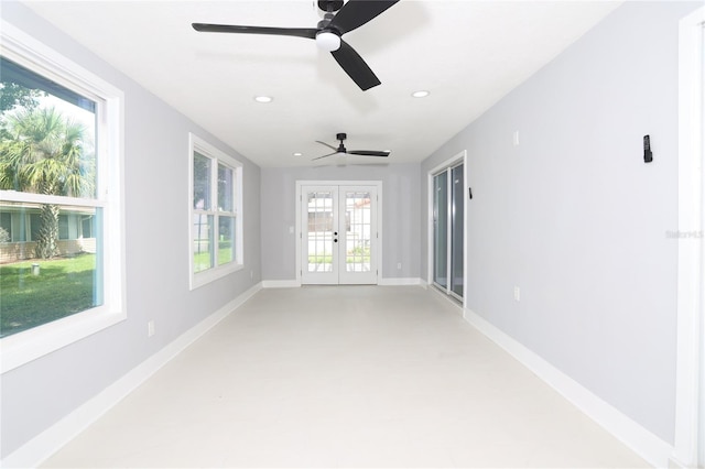 empty room featuring ceiling fan, plenty of natural light, and french doors