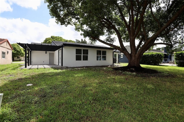 back of property with a lawn and a patio area