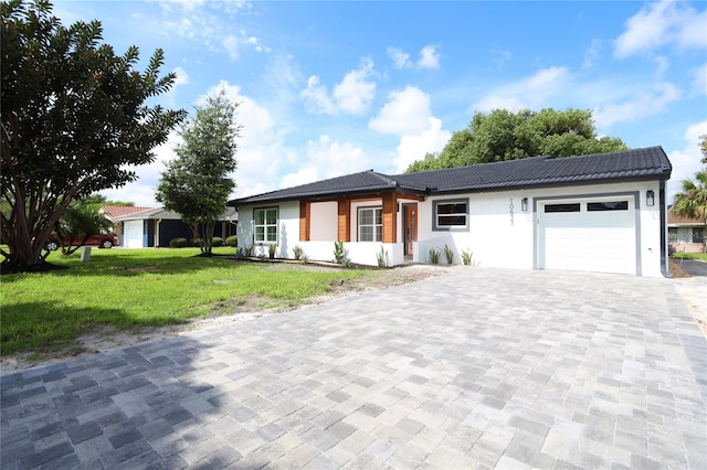 ranch-style house featuring a garage and a front lawn