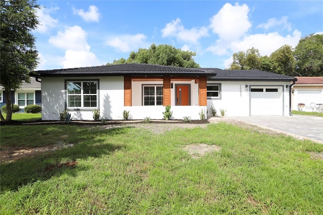 ranch-style home featuring a garage and a front lawn