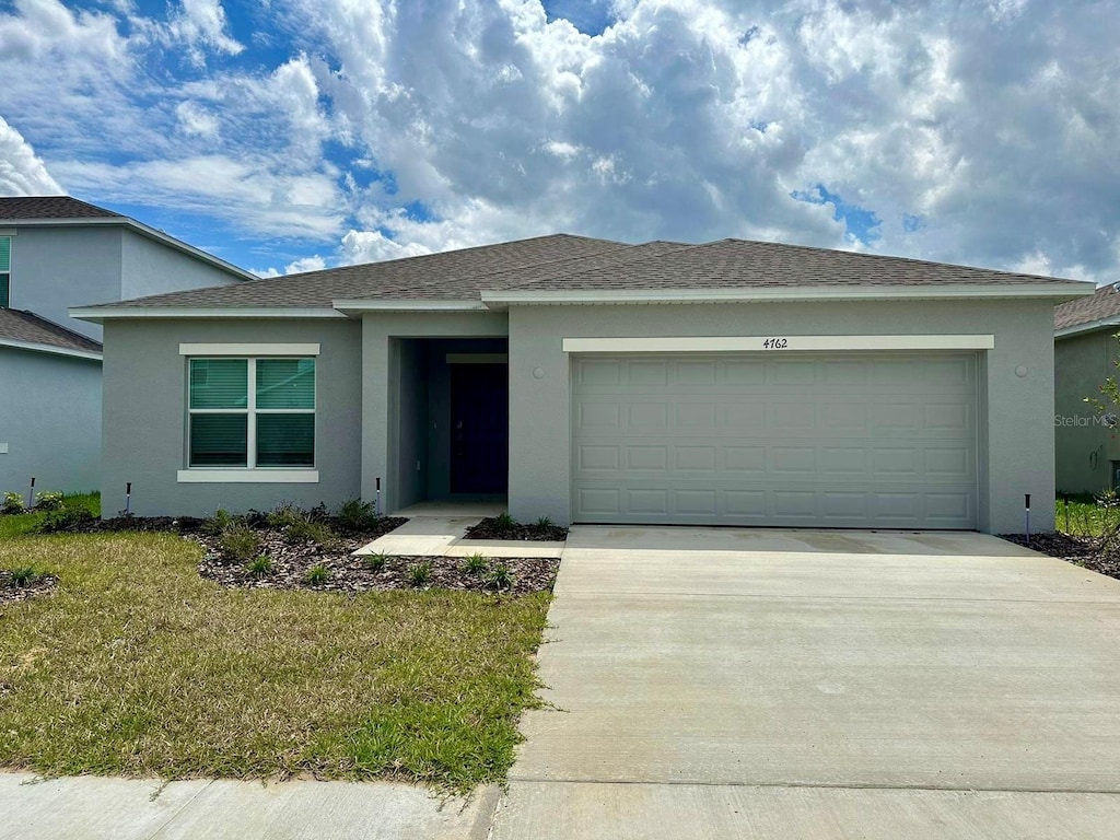 view of front of home featuring a garage and a front yard