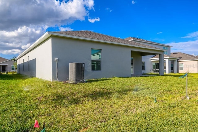 back of house featuring central AC and a yard