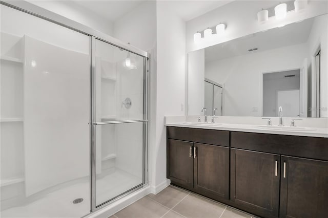 bathroom featuring tile patterned flooring, vanity, and walk in shower