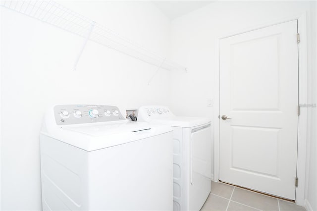 clothes washing area featuring separate washer and dryer and light tile patterned floors