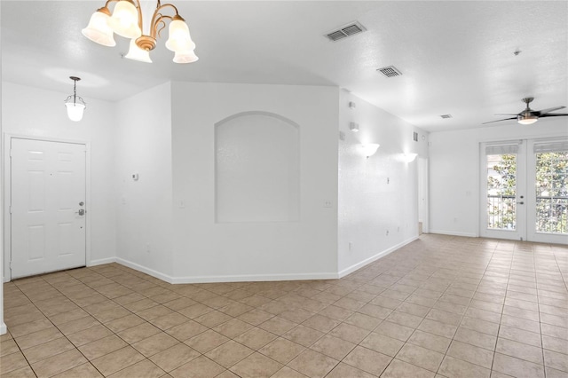 spare room featuring ceiling fan with notable chandelier and light tile patterned flooring