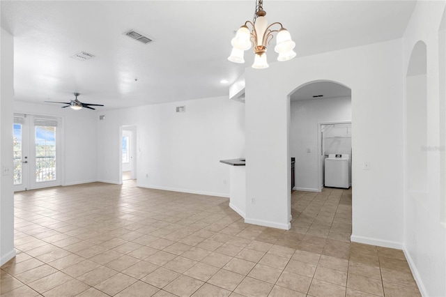 empty room featuring ceiling fan with notable chandelier, washer / clothes dryer, and light tile patterned floors