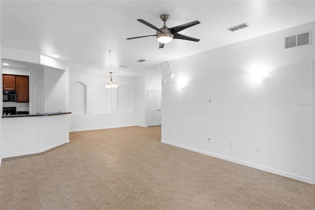 unfurnished living room featuring ceiling fan with notable chandelier