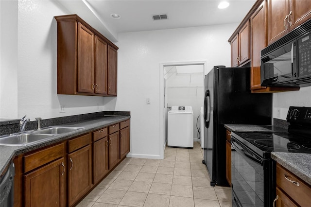 kitchen with light tile patterned floors, washer / clothes dryer, sink, and black appliances