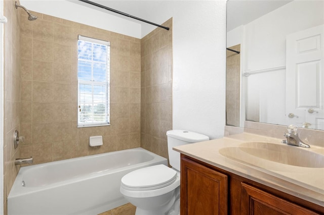 full bathroom featuring tiled shower / bath, vanity, and toilet