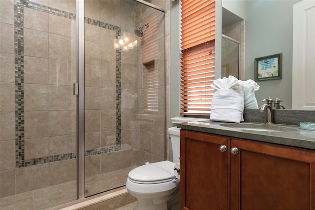 bathroom featuring vanity, toilet, and walk in shower