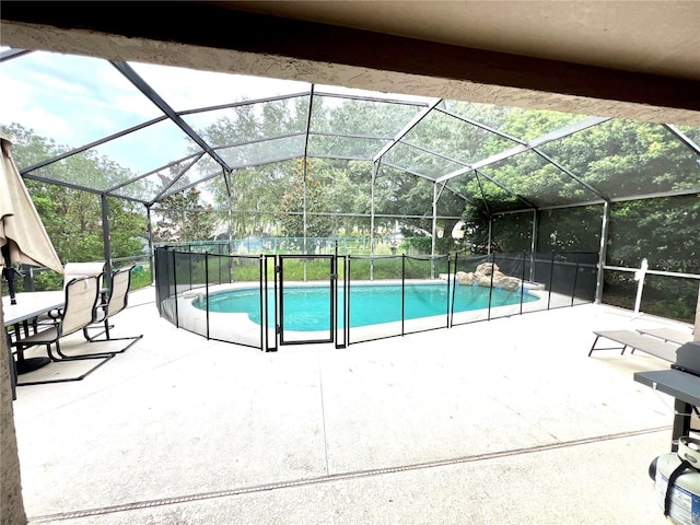 view of swimming pool with glass enclosure and a patio