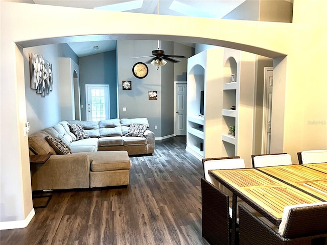 living room with lofted ceiling, dark hardwood / wood-style flooring, ceiling fan, and built in shelves