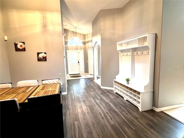 interior space with high vaulted ceiling and dark wood-type flooring