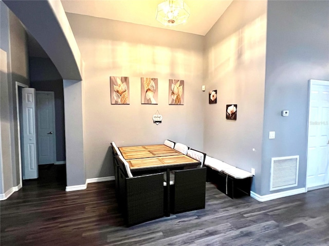 dining area with dark hardwood / wood-style flooring and high vaulted ceiling