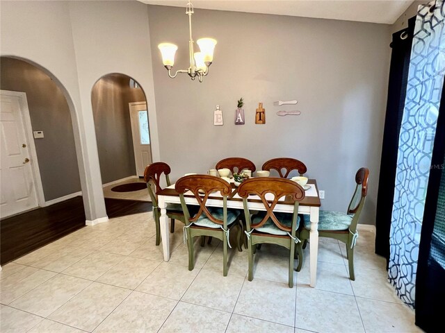 2556 Bear Creek Ct, Kissimmee, FL 34747 - dining area with arched walkways, a chandelier, baseboards, and light tile patterned floors