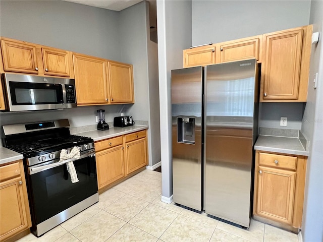 kitchen with stainless steel appliances and light tile patterned flooring