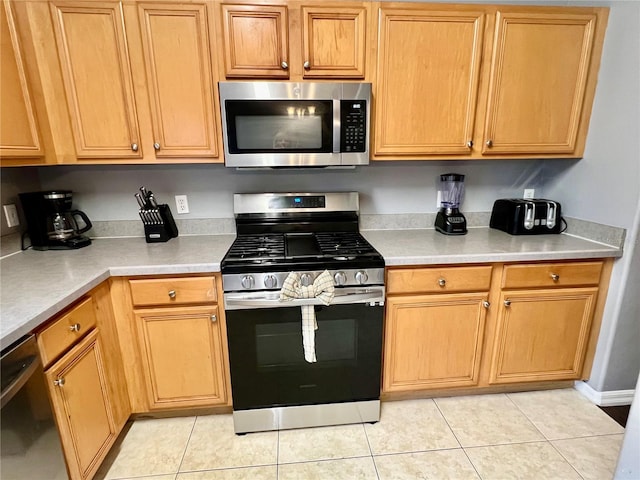 kitchen with appliances with stainless steel finishes and light tile patterned floors