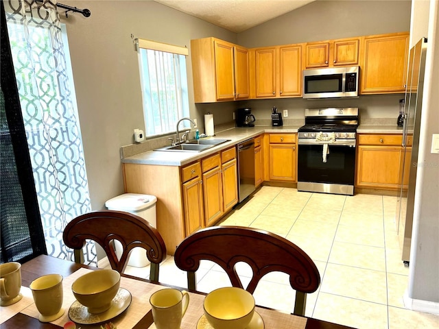 2556 Bear Creek Ct, Kissimmee, FL 34747 - kitchen with appliances with stainless steel finishes, a sink, vaulted ceiling, light countertops, and light tile patterned flooring