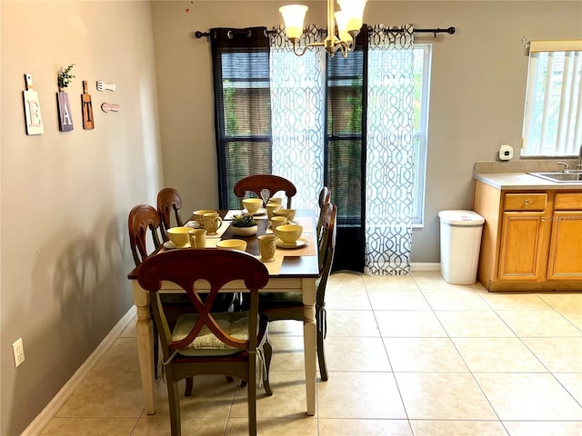 tiled dining room with a notable chandelier, sink, and plenty of natural light