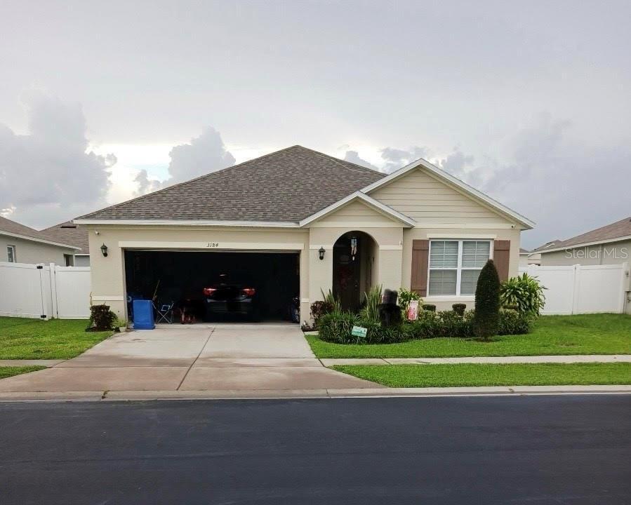 single story home with a garage and a front lawn