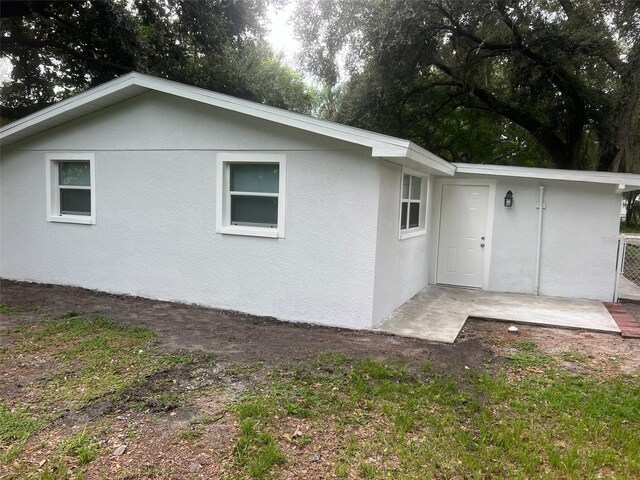 rear view of house featuring stucco siding